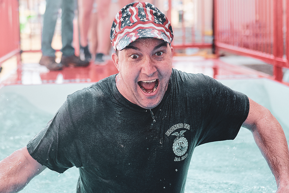 An excited man wearing a black shirt stands in the Plungester pool