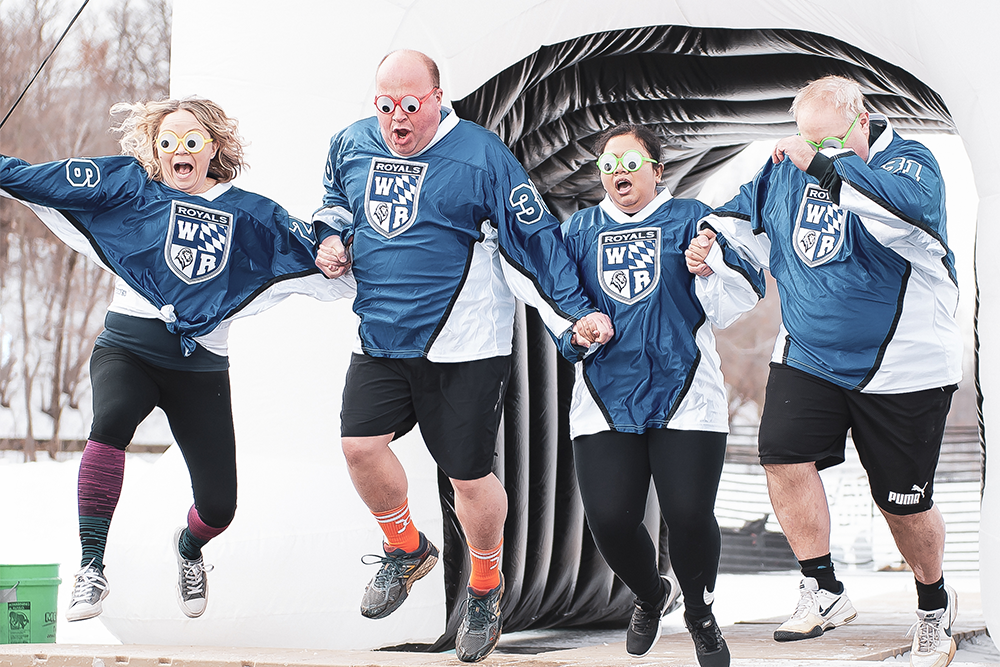 Four Plungers wearing blue shirts and excited expressions jump into the Plunge hole